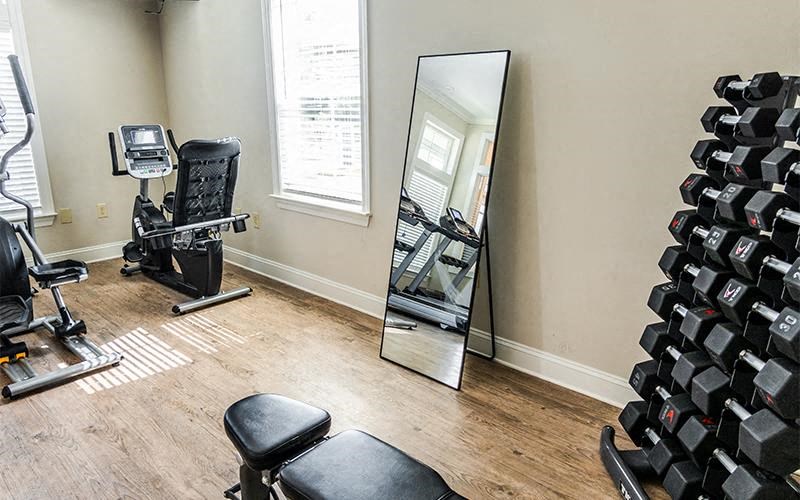 a gym with a mirror and some chairs