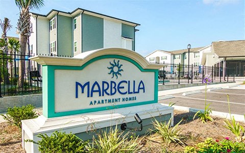 a sign for marbella apartments in front of a street
