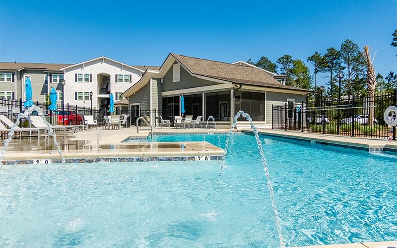 a large swimming pool with a house in the background