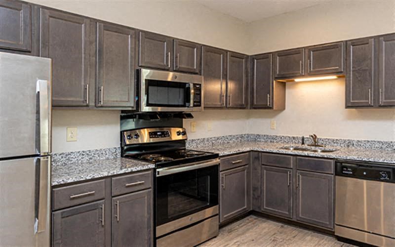 a kitchen with stainless steel appliances and gray cabinets