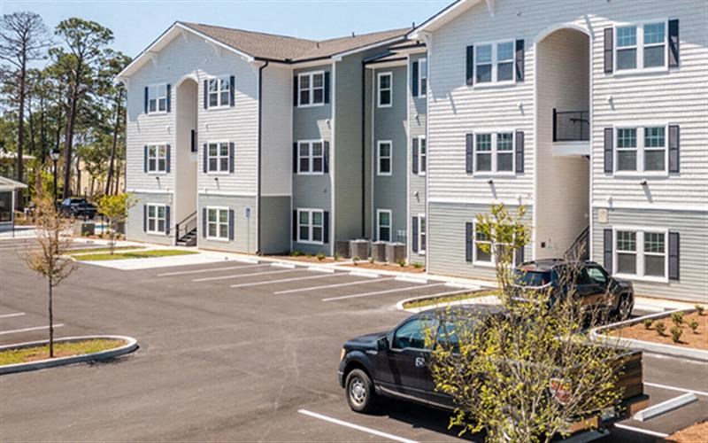 a car parked in a parking lot in front of an apartment building