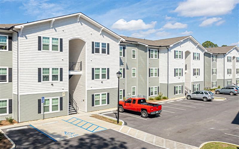 a red truck parked in front of an apartment building
