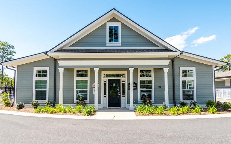 a blue house with a front porch and a black door