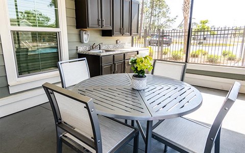 a patio with a table and chairs and a kitchen