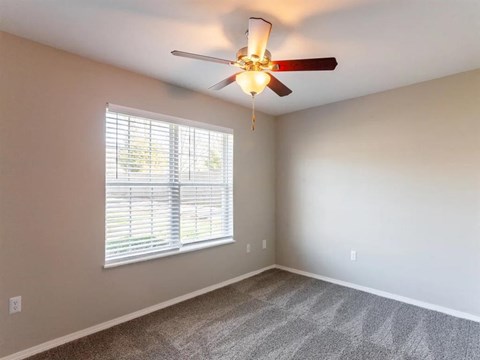 a bedroom with a ceiling fan and a window