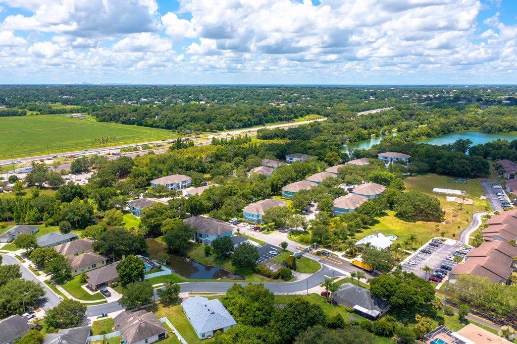 an aerial view of a neighborhood with houses and trees and a lake at Waters Edge Apartments, Lakeland