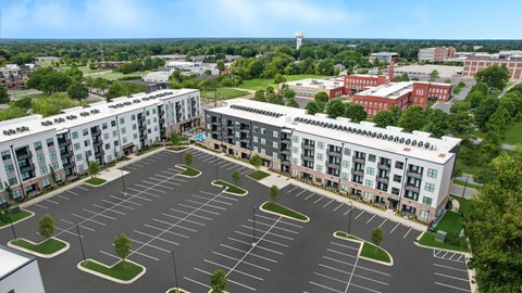 an aerial view of an empty parking lot and apartment buildings
