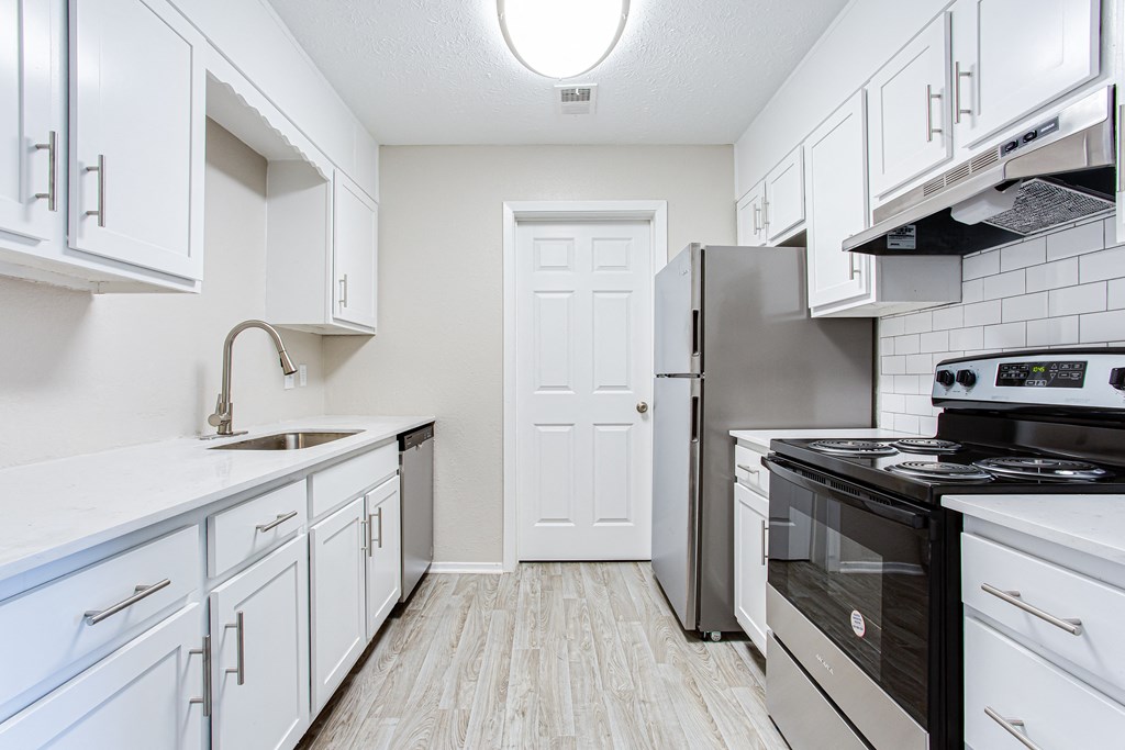 Modern kitchen with white countertops and white cabinets at Ascend at Stone Mountain apartments. Stone Mountain, GA 30088.