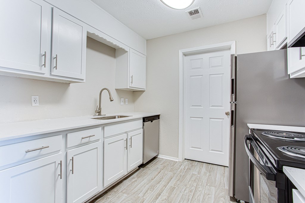 A modern kitchen with stainless-steel appliances and white cabinets at Ascend at Stone Mountain apartments. Stone Mountain, GA 30088.