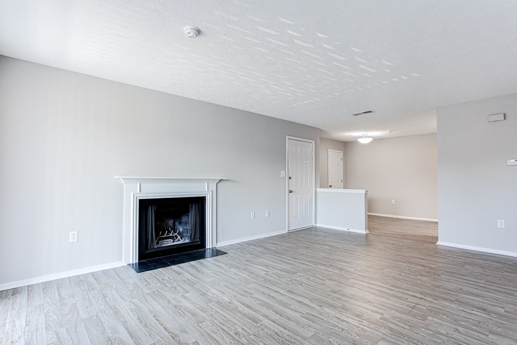 A spacious living room with fireplace and entryway at Ascend at Stone Mountain apartments. Stone Mountain, GA 30088.