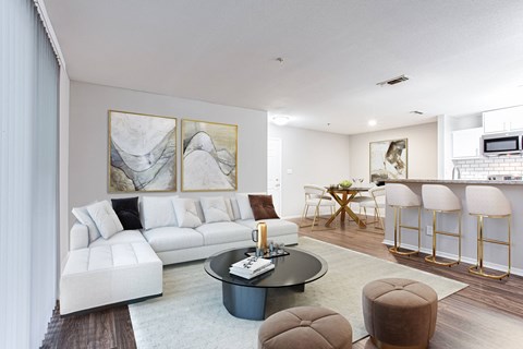 a living room with a white couch and coffee table and a kitchen with a bar  at Avenues of Kennesaw East & West, Georgia, 30144