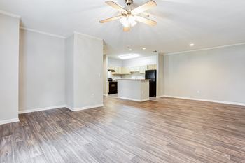 an empty living room with a kitchen in the background  at Avenues of Kennesaw East & West, Kennesaw Georgia