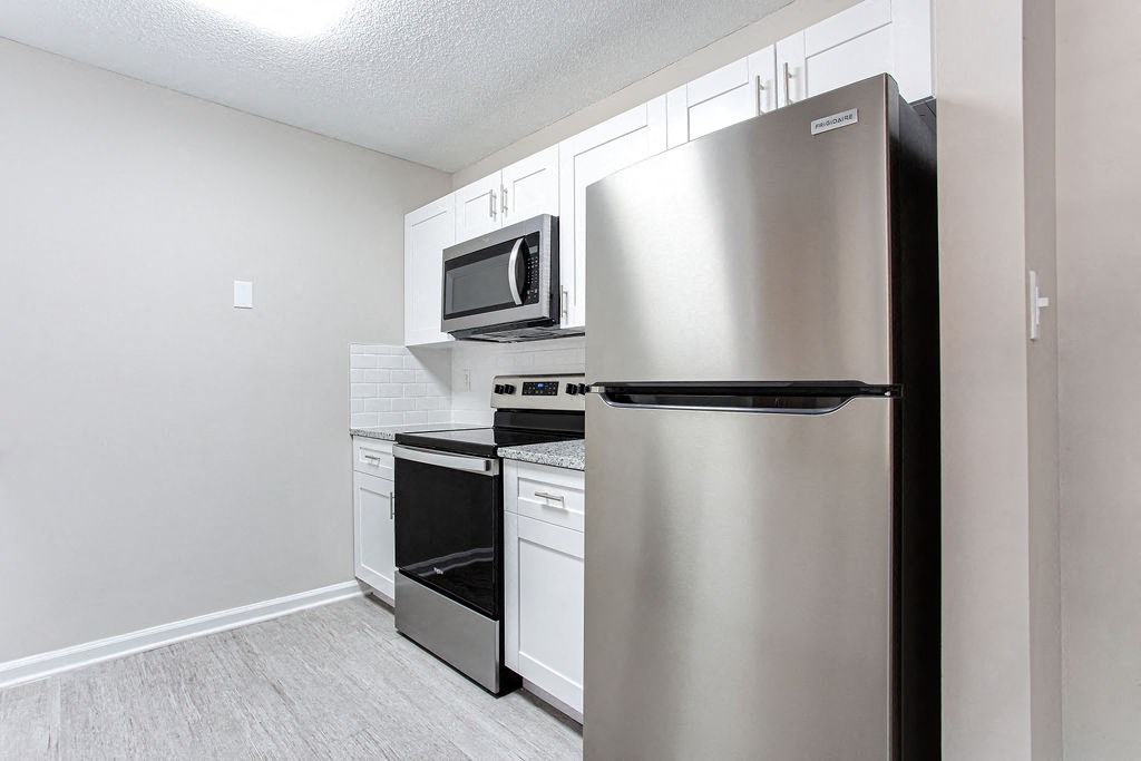 a kitchen with white cabinets and stainless steel appliances