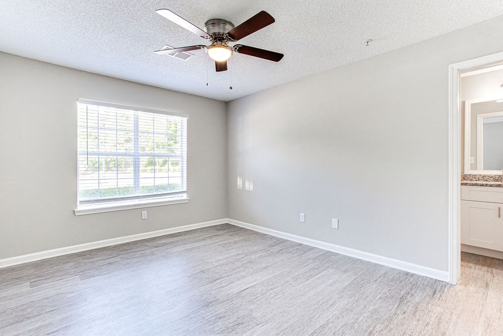 an empty bedroom with a ceiling fan