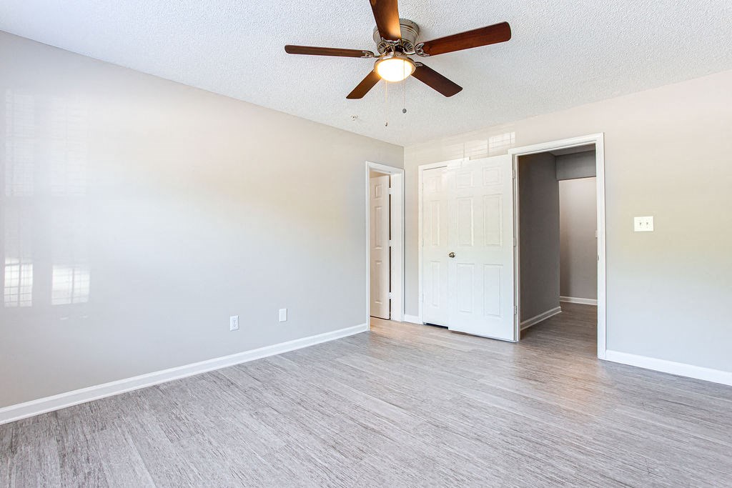an empty bedroom with a ceiling fan