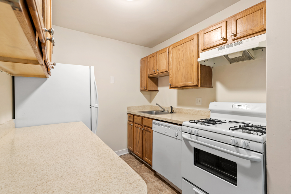 a kitchen with white appliances and wooden cabinets