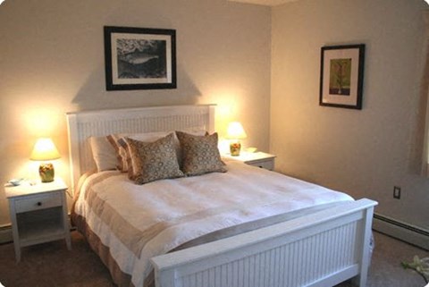a bedroom with a white bed and two lamps