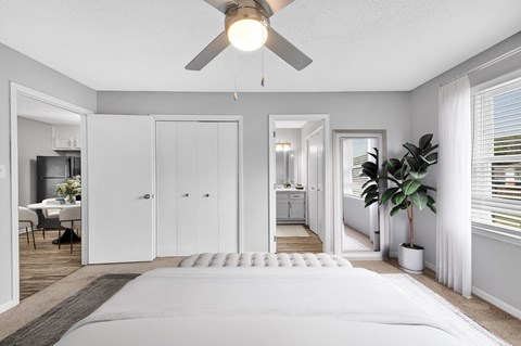a bedroom with a large bed and a ceiling fan