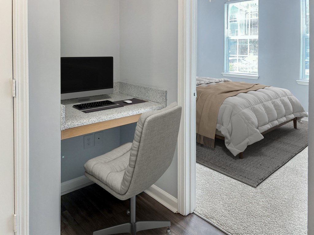 a bedroom with a bed and a desk with a computer