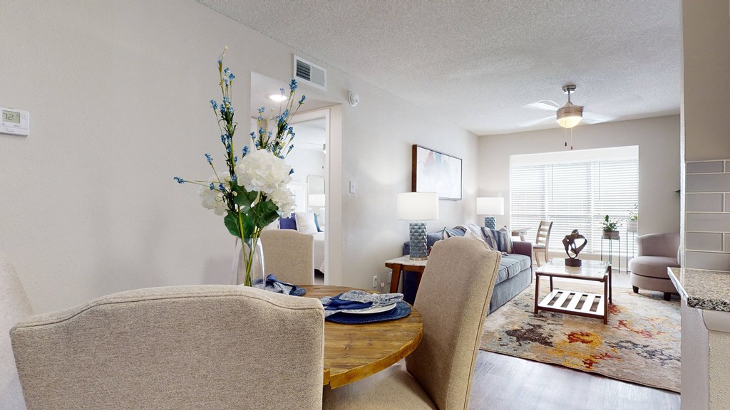a living room with a table and chairs and a couch in the background at Breckinridge Vue, Duluth, GA