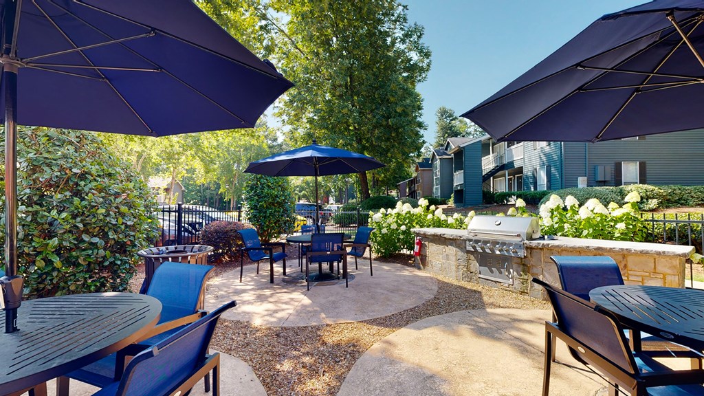 an outdoor patio with blue chairs and umbrellas at Breckinridge Vue, Georgia, 30096