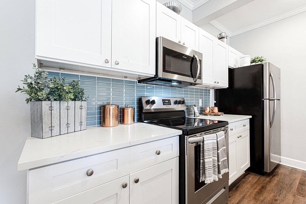 a kitchen with white cabinets and black appliances and a black refrigerator