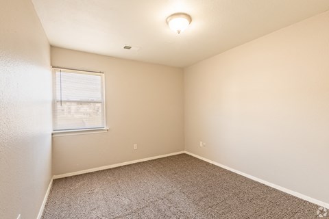 a bedroom with beige walls and carpet