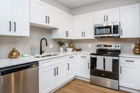 A kitchen with white cabinets and stainless steel appliances.