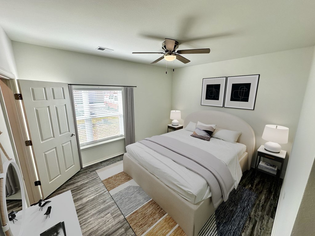 A bedroom with a bed, nightstand, and window.