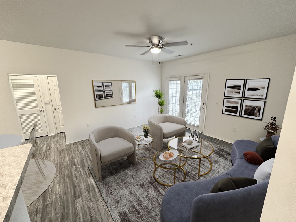 A living room with a grey sofa, a grey armchair, a coffee table, and a ceiling fan.