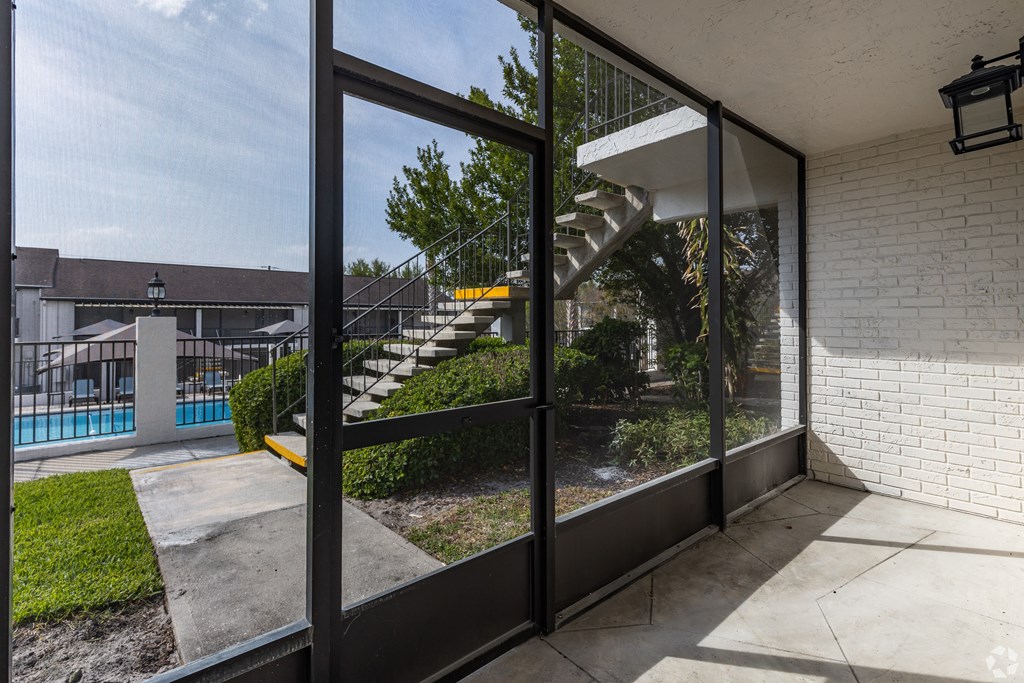 the view of the pool from the patio of a house with glass doors at The Essex, Altamonte Springs, FL, 32701
