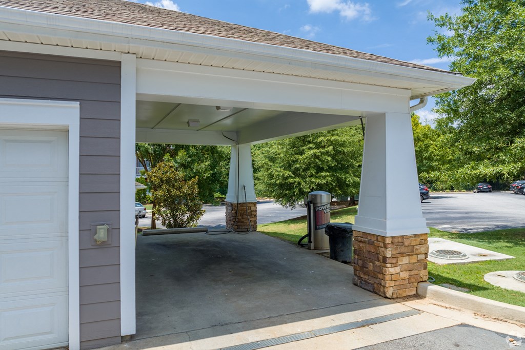 a carport with a driveway in front of a house