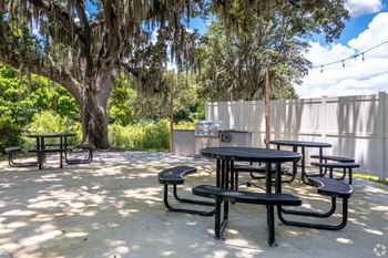 our patio has tables and chairs and a grill at Waters Edge Apartments, Lakeland, FL, 33803