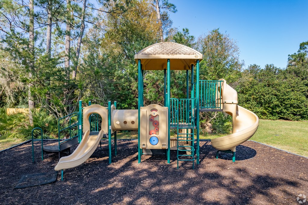 a playground with a slide and a swing set at The Adelaide, Florida, 32821