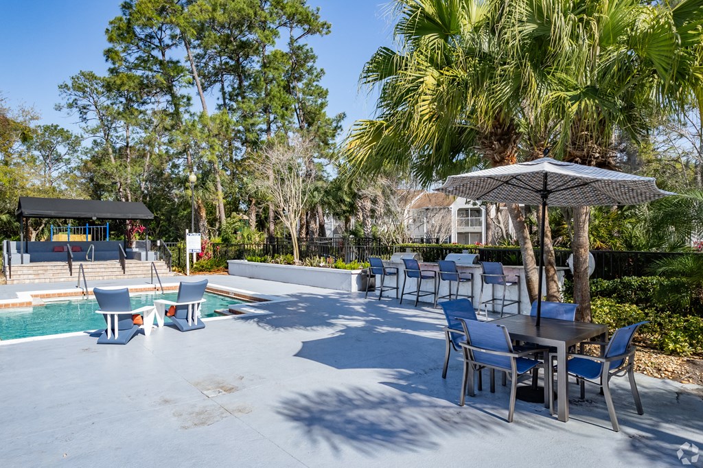 a patio with tables and chairs and a swimming pool at The Adelaide, Orlando, FL