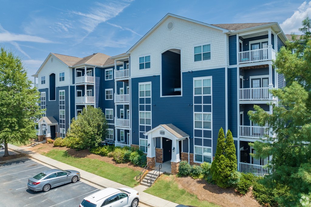 an aerial view of an apartment complex with cars parked in a parking lot