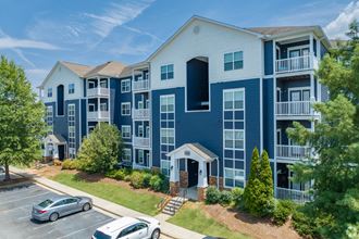 an aerial view of an apartment complex with cars parked in a parking lot
