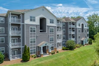 an apartment building on a hill with a grassy area in front of it