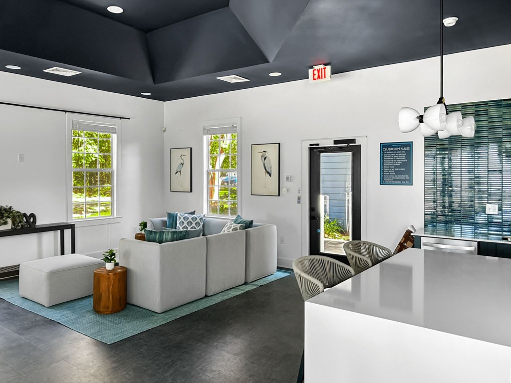 A white reception area with a white sofa and a white chair.