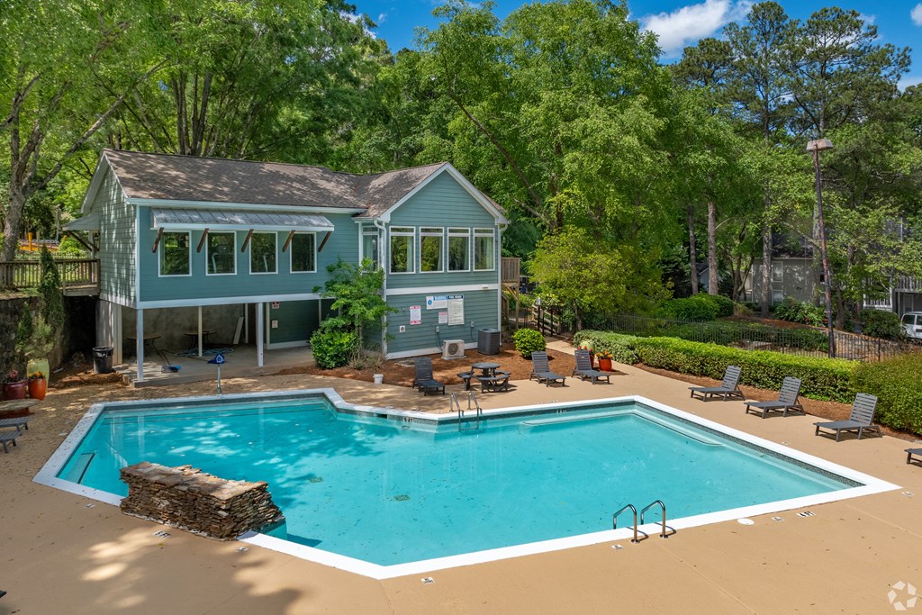 a swimming pool with a house in the background