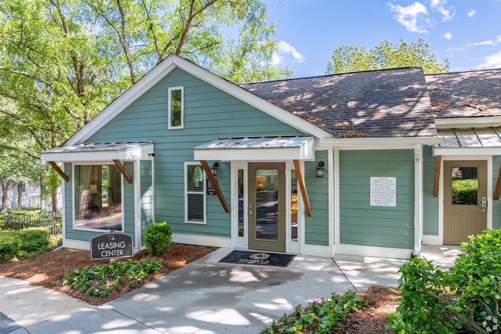 a green house with a sidewalk in front of it