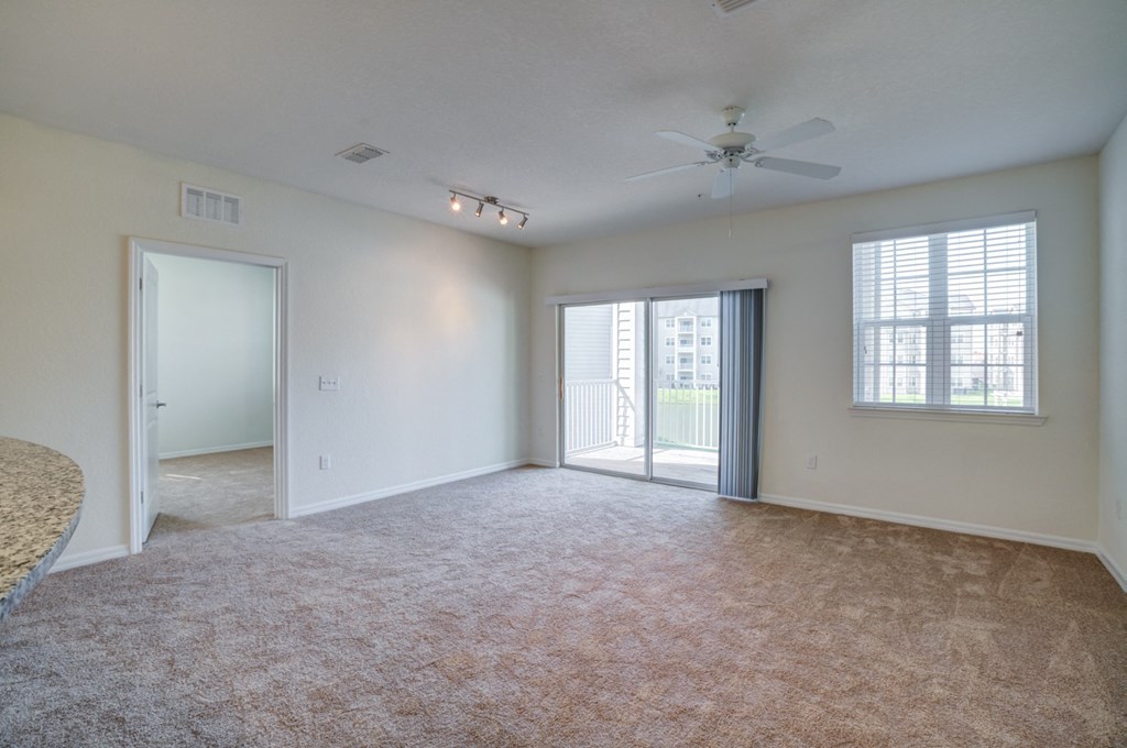 a bedroom with a ceiling fan and a door leading to a balcony  at Century Avenues, Lakeland, FL