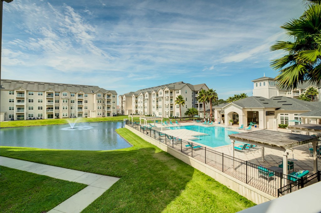 a swimming pool with a fountain and a gazebo in front of a building  at Century Avenues, Florida, 33813