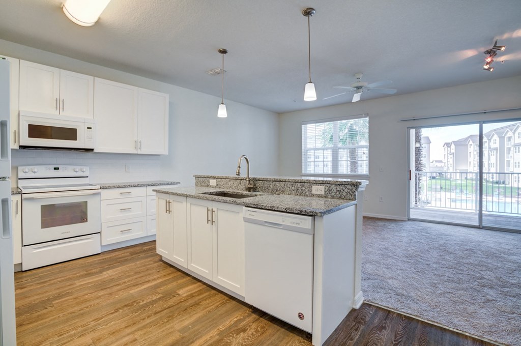 a kitchen and living room with a sliding glass door to a balcony  at Century Avenues, Lakeland, Florida