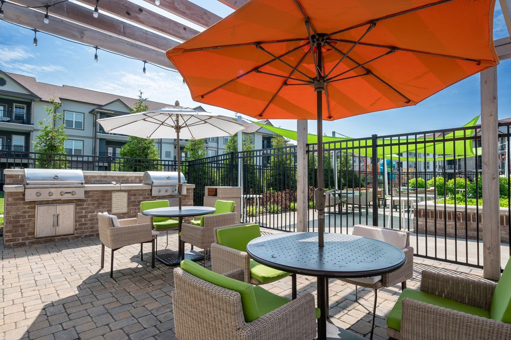 a patio with tables chairs and umbrellas at Century Belmont Station, Louisville, KY, 40243