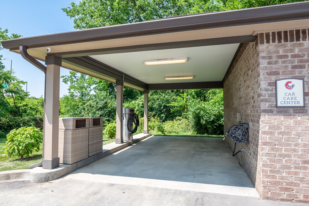a gas station with a bench and a trash can in front of it at Century Belmont Station, Louisville, Kentucky