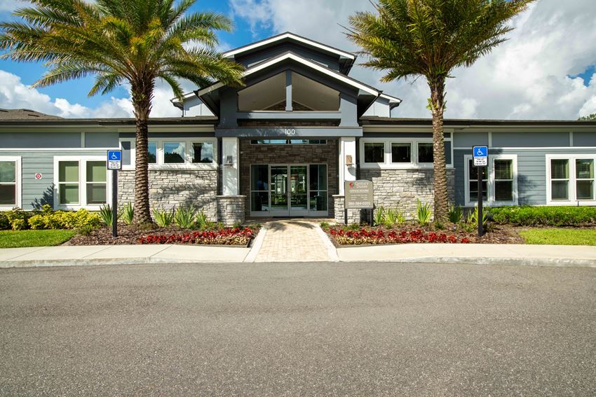 the front of a building with palm trees in front of it