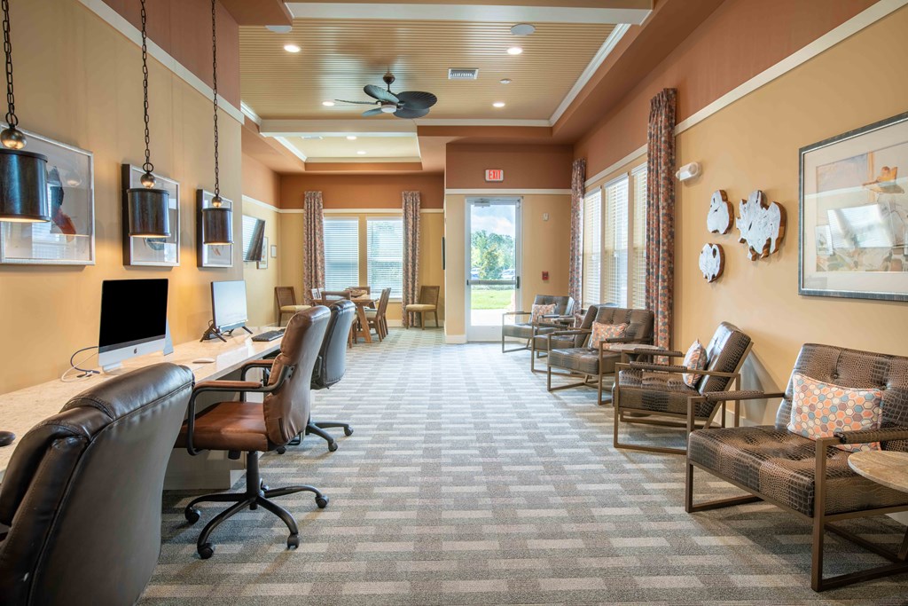a conference room with chairs and a desk and a computer at Century Dunes Apartments, Deland, FL