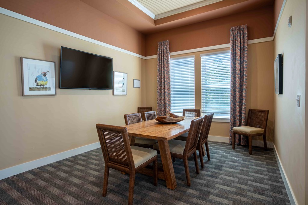 a dining room with a table and chairs and a television at Century Dunes Apartments, Deland, FL