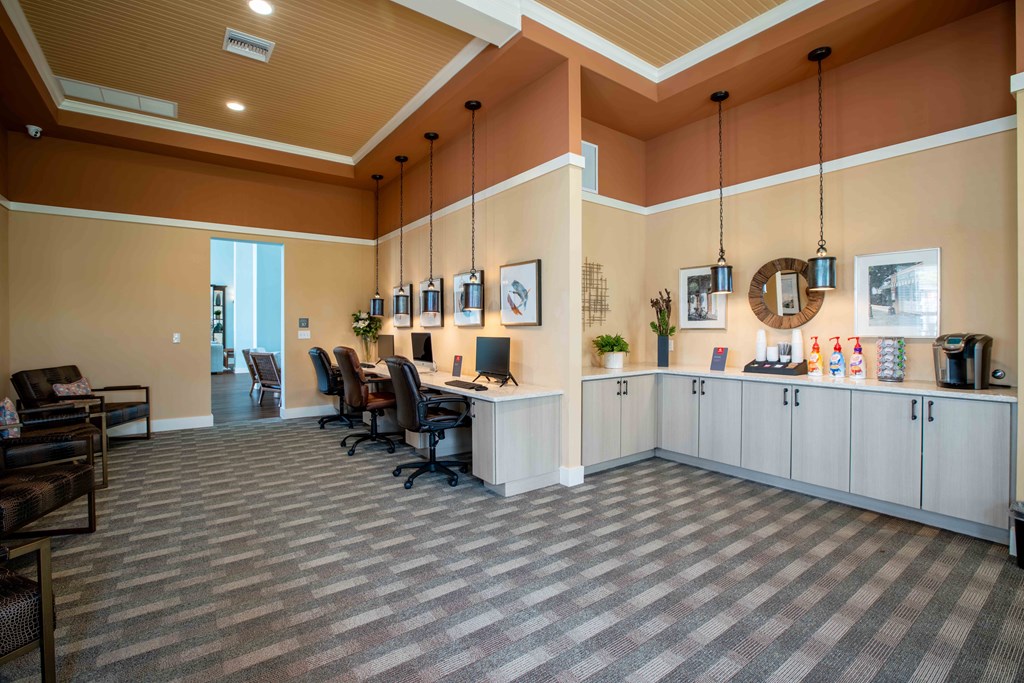 a large lobby with a desk and chairs and a counter at Century Dunes Apartments, Deland, 32724